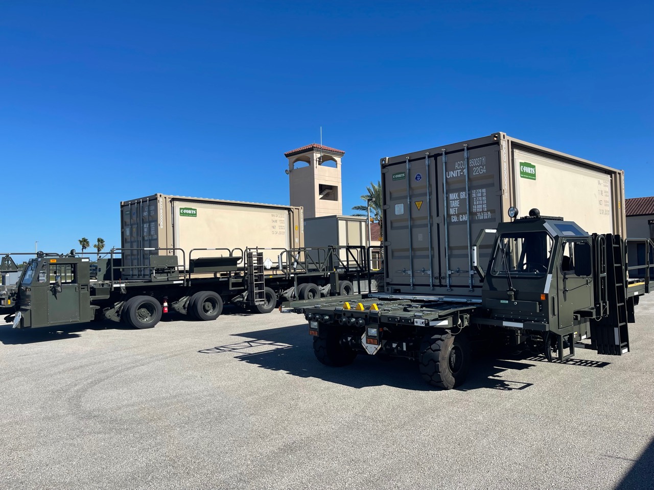 Folded C-FORTS shelters loaded on military-style transport vehicles