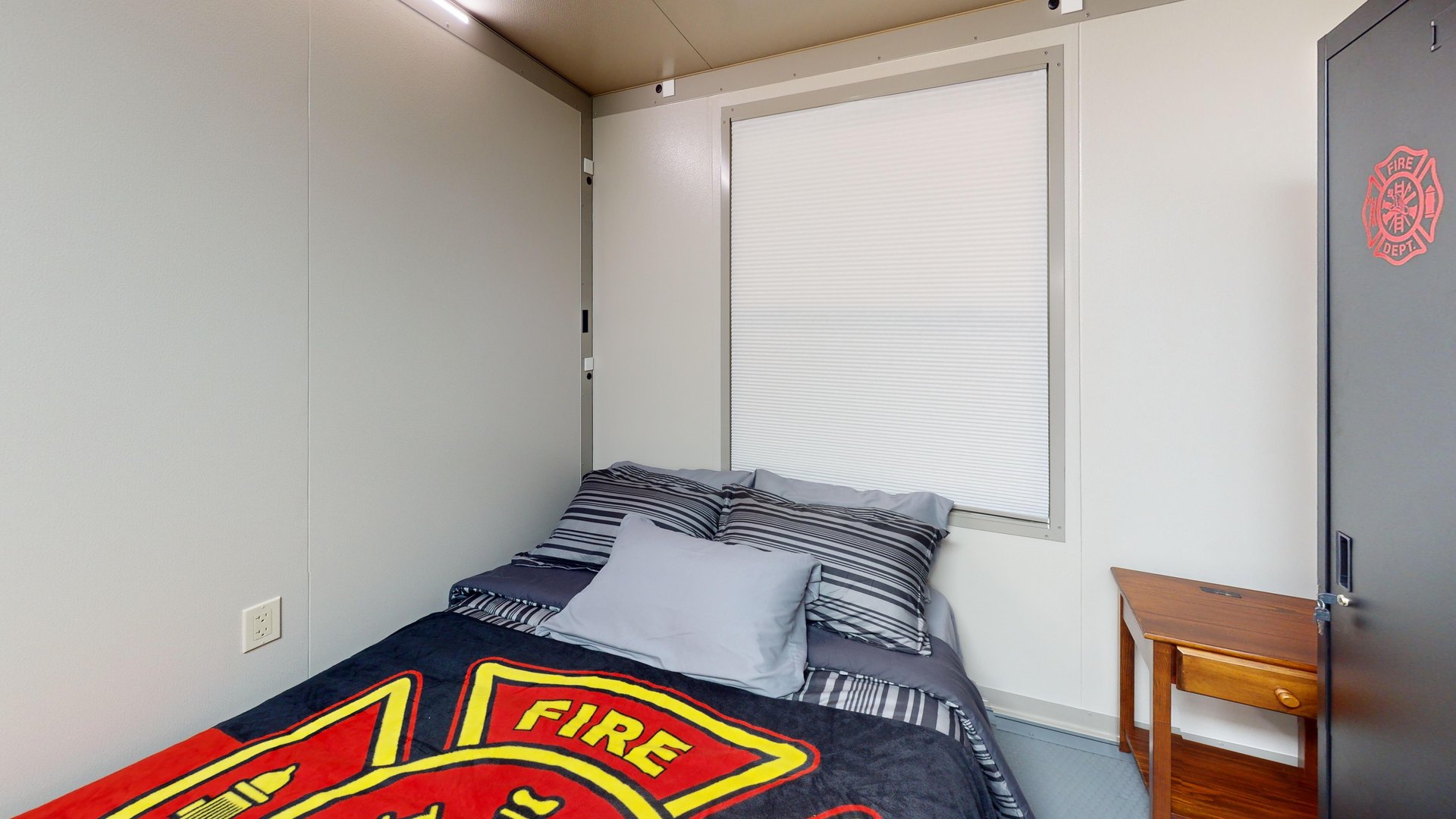 Fire-station sleeping room with a bed and personal storage locker