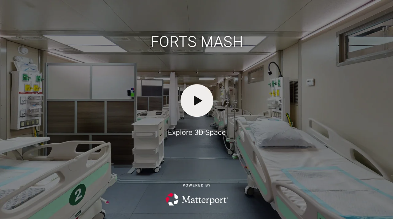 Empty hospital room with several unoccupied beds, medical equipment, and nursing station, labeled 'Forts Mash'.