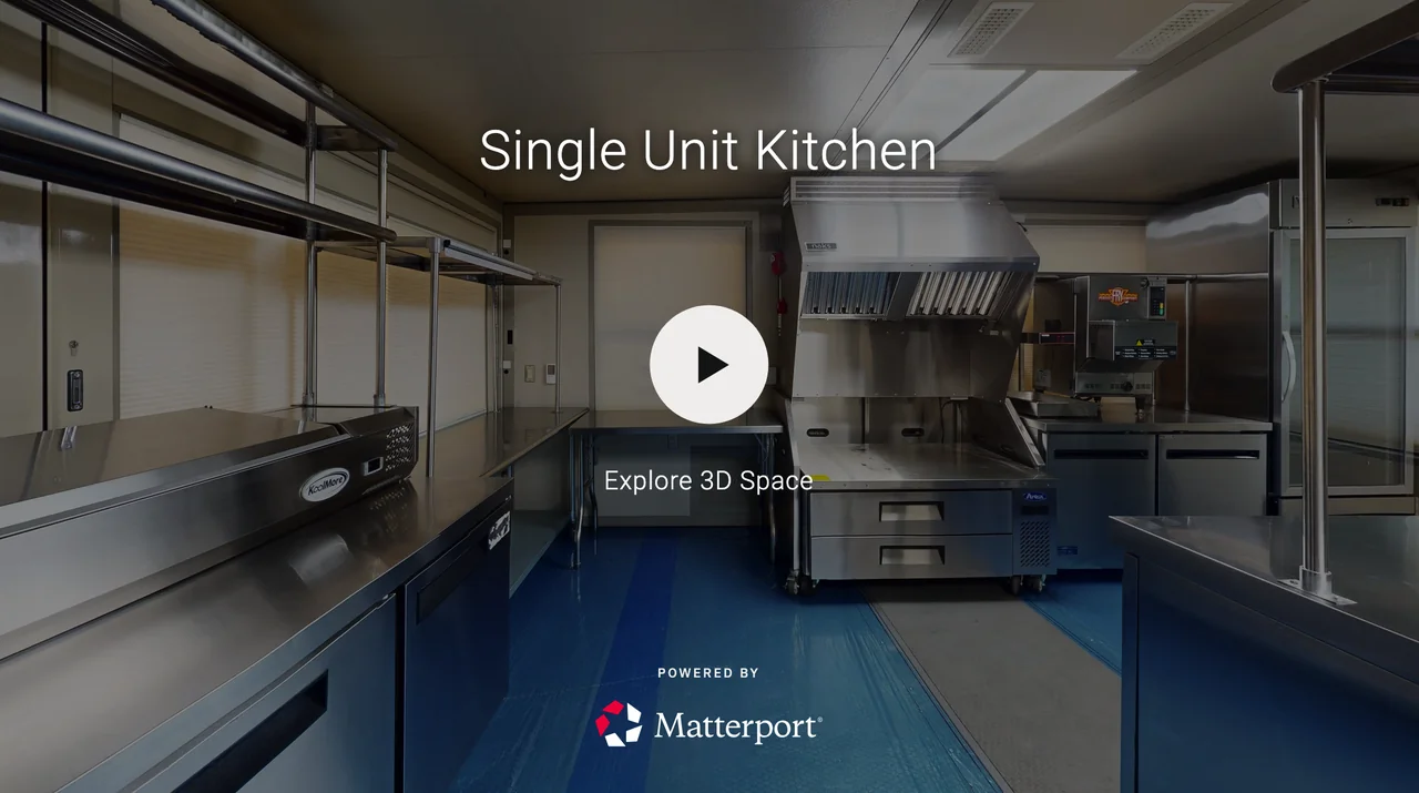 Interior of a compact kitchen with stainless steel counters, a warming drawer, a commercial fryer, and industrial cooking appliances, labeled as Single Unit Kitchen.
