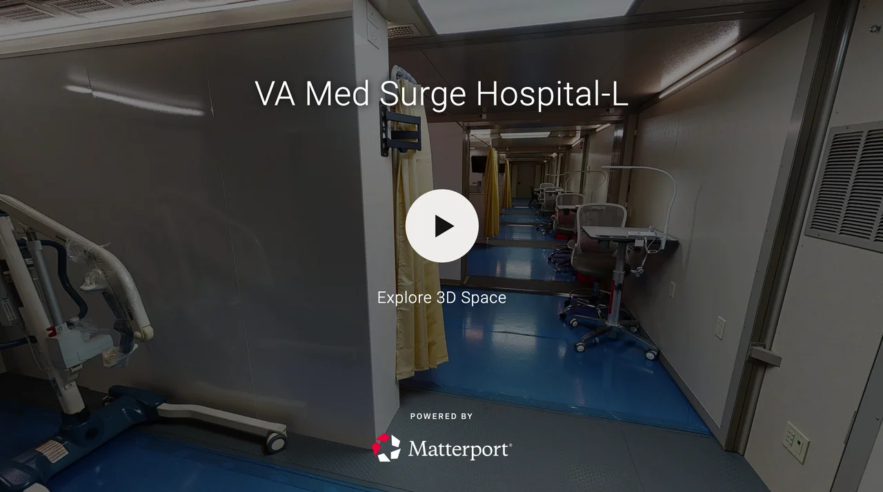 Hospital corridor with patient rooms separated by yellow privacy curtains, medical equipment, and chairs along the wall
